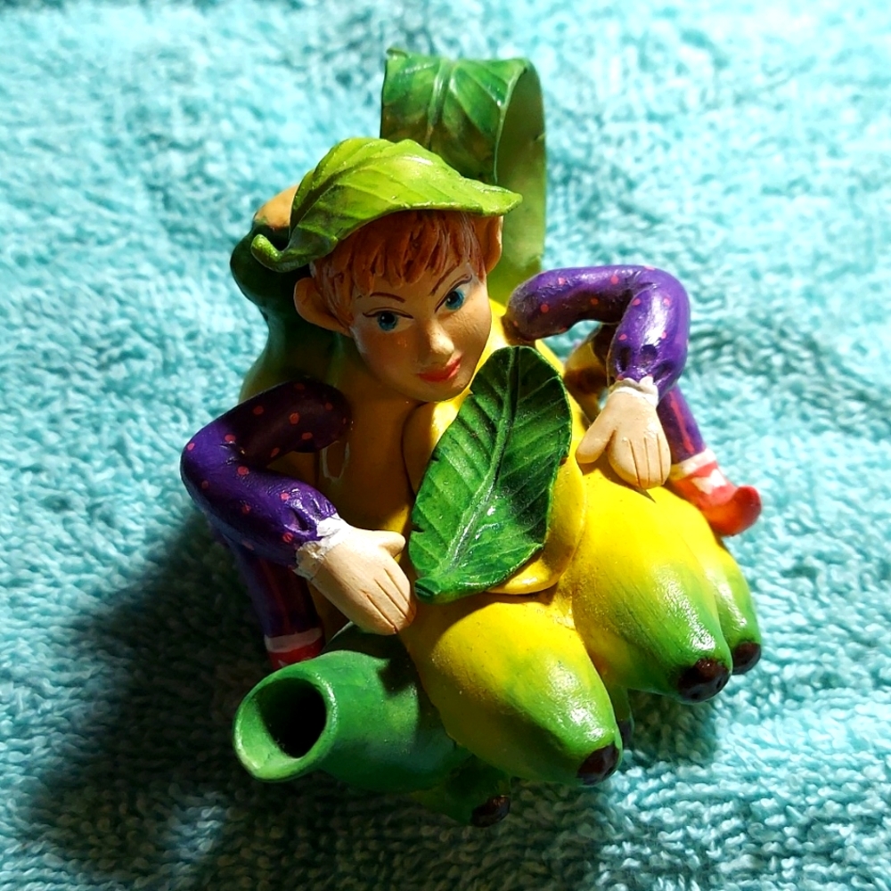 Vintage collectible elf sitting in banana boat with removable leaf